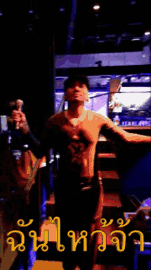 a man in a hat is standing on a set of stairs in a dark room with chinese writing