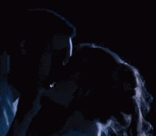 a man and woman are kissing in the dark