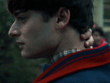 a close up of a person 's neck with a red sweater
