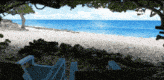 a blue chair sits on a beach looking out to the ocean