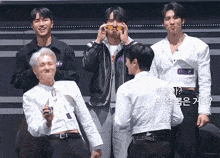 a group of young men standing next to each other on a stage .