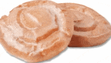 two glazed donuts are sitting on top of each other on a white background .