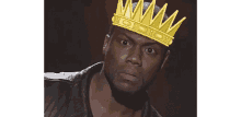 a man is wearing a crown on his head and looking at the camera .