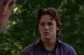 a young man wearing a blue shirt that says ' abercrombie & fitch ' on it looks surprised