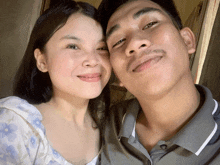 a man and woman are posing for a picture and the woman is smiling