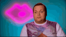 a man is making a face in front of a pink heart