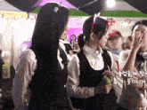 a girl wearing a headband that says ' bunny ears ' on it stands in a crowd