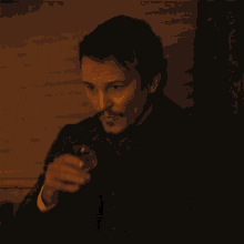 a man with a mustache is holding a glass
