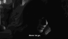 a black and white photo of a woman and a man with the words `` never let go '' written on the bottom .