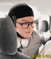 a man wearing glasses and a hat is sitting in the back seat of a car with the word ocean on the bottom right