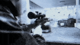 a man is holding a sniper rifle in a room