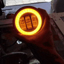 a person is holding a round object with a yellow light inside