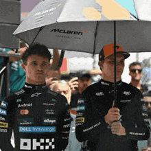 a man holding an umbrella that says mclaren