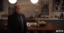 a man in a suit and tie stands in a kitchen with a netflix logo on the counter
