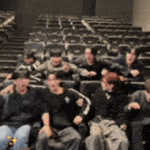 a group of people are sitting in a theater laughing and hugging each other