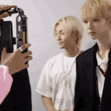 a person is taking a picture of two young men .