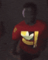 a man wearing a red adidas shirt with the letter b on the front