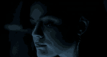 a close up of a woman 's face in the dark with a surprised look on her face