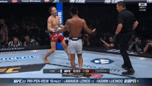 a man in a venum shorts is fighting another man in a boxing ring