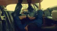 a man is laying in the back seat of a car