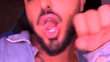 a man with a beard is making a funny face with his tongue out .