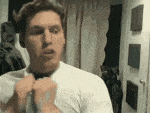 a man in a white shirt is brushing his teeth with pink toothpaste