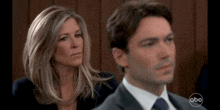 a man and a woman are sitting in a court room .
