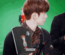 a young man is holding a book with a woody character on it .