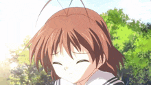 a close up of a girl 's face with her eyes closed and trees in the background