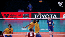 a group of volleyball players are playing in front of a toyota ad