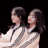two girls are standing next to each other and one has a blue sticker on her face that says ' a ' on it