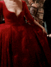 a woman in a red dress is standing in a room