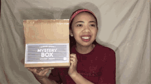 a woman holding a box that says mystery box