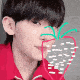 a young man in a red shirt has a strawberry drawn on his face .