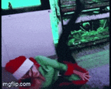a person wearing a santa hat is laying on the ground