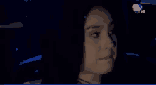a close up of a woman 's face in a dark room with a hd logo in the background