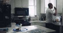 a man standing in a kitchen with a whirlpool microwave