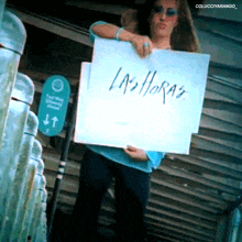 a woman holds a sign that says las horas
