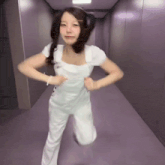 a woman in a white dress is dancing in a hallway ..