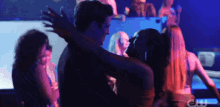 a man and a woman are hugging in a club with the letters cw on the bottom