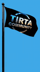 a black flag that says tirta community is flying in the wind