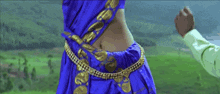 a woman in a blue top is standing in a field of grass .