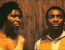 a man and a woman are standing next to each other looking at each other .