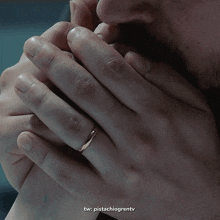 a close up of a person holding another person 's hand with a ring on it