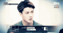 a close up of a young man 's face with a mnet logo in the background .