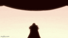 a silhouette of a person standing in front of a large object in the air .