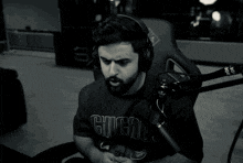 a man wearing headphones is singing into a microphone and his shirt says ig