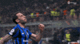 a soccer player in a blue and black jersey with the number 3 on it