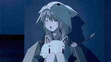 a girl is wearing a cat hood and holding a cat toy