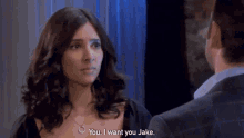 a woman says you i want you jake in front of a man in a suit